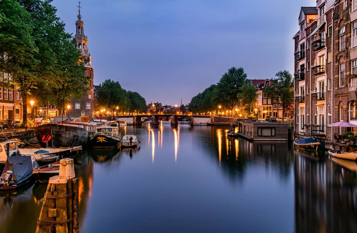 Canal de Ámsterdam iluminado al anochecer