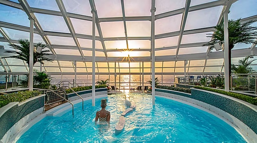 Solárium con piscina a bordo del crucero al atardecer